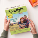 Titelbild des Magazins „Spotlight“ in grün-beiger Farbgestaltung; mittig ein Foto eines lachenden weiblichen und männlichen Paares auf einem Festivalgelände mit Union-Jack-Flagge im Hintergrund. Aufdrucke: „CELEBRATING THE SUMMER 2026“, „Dream safari destination BOTSWANA“, „The 15 best events in the English-speaking world“ sowie Themen wie „UNDERSTANDING THE USA“, „A DAY IN INVERNESS“ und „THE MADNESS OF CRICKET“.