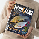 Titelblatt des Magazins „Fisch & Fang – Das Erlebnis-Magazin für Angler“, gehalten von einer Person in beigem Strickpullover vor neutralem Hintergrund. Im Mittelpunkt zwei nebeneinander liegende Fische auf dunklem Netzgrund, darüber Schlagzeilen wie „Schichtwechsel“, „Räucherarm“, „Fallensteller“ und Haupttitel „Aal modern – Mit Köfi-Kopf am T-Rig“, zusätzlich Hinweis auf ein Extra-Teil unten rechts.