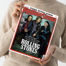 Person in beigem Strickpullover hält die Zeitschrift „Rolling Stone“ mit rotem Rand und schwarzer Schrift. Auf dem Cover sitzen drei männliche Personen vor graugrünem Hintergrund. Sichtbare Texte: „Rolling Stone“, „Mick Jagger über die Lage der Welt und die Zukunft der Rolling Stones“, „Das Interview“, sowie kleinere Überschriften zu „Taylor Swift“, „Mark in the Junkyard“, „Laura Nyro“, „Olivia Dean“, „Deep Purple“, „Beth Orton“.