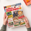 Titelblatt der Zeitschrift „selber machen! DIY – Bauen, Gestalten, Renovieren“, Ausgabe Juni 2023, gehalten von zwei Händen über hellem Hintergrund. Im Mittelpunkt ein Mann in Arbeitskleidung, der eine Holzterrasse baut. Textelemente u. a.: „TERRASSEN-IDEEN selber realisieren“, „LASUREN UND LACKE“, „Innovative Mähroboter“, „Geräteversteck“, „Kuschelplätze für Hund und Katze“ und „Kochen unter freiem Himmel“.