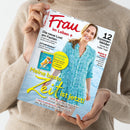 Magazincover „Frau im Leben+“ wird von einer Person in beigefarbenem Pullover mit beiden Händen gehalten, zeigt eine lächelnde Frau im türkisgemusterten Kleid am Wasser. Aufdrucke: „Meine beste Zeit ist jetzt!“, „12 Sommerkleider – Mode für heiße Tage“, „Die neue Lust am Fasten“, „Ich hab Rücken“, gelber Kreis mit „Sommer-Spezial – Taschenbücher für den Urlaub“, und Hinweis auf Beitrag von Ildikó von Kürthy.