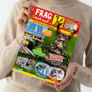 Person in beigefarbenem Pullover hält das Kinder‑Wissensmagazin „FRAG doch mal…“ mit rotem Titelkopf und gelbem Hintergrund. Auf dem Cover großer Hirschkäfer, Text „HIRSCHKÄFER! Welche haben ein Geweih?“, Fotos von Solaranlage, Zug, Achterbahn, Rafting und Erdmännchen mit Überschriften wie „Sonnenenergie!“, „Zugabenteuer!“, „WAS ist Rafting?“ sowie Hinweis auf „2 Poster“ unten links.