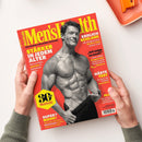 Titelblatt der Zeitschrift „Men’s Health“ mit rotem Hintergrund, gelbem Logo und schwarzer Schrift. Zentral ein schwarz-weiß-Foto eines muskulösen, älteren männlichen Models mit nacktem Oberkörper, das mit einer Hand die Hose leicht nach unten zieht. Textzeilen u. a.: „STÄRKER IN JEDEM ALTER“, „ENDLICH SCHLANK“, „30 Jahre Men’s Health“, „HÄRTE TEST“ und „SUPER? MANN!“. Zwei Hände halten das Magazin über einer hellen Oberfläche.