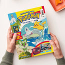 Titelbild des „Pokémon – Das offizielle Magazin“ mit gelbem Schriftzug „Schnapp sie dir alle!“, zeigt die Figuren Pikachu, ein blau-graues Delfin-Pokémon und ein grünes Pflanzen-Pokémon vor tropischem Strand und Meer, unten mit kleinen Abbildungen von Sammelkarten und Postern, Textfelder in Rot und Gelb mit Hinweis „COOLE POSTER“ und „Gewinne 16 3D-Puzzles!“, gehalten von zwei hellhäutigen Händen über hellem Tisch.