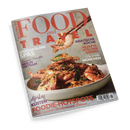 Titelbild des Magazins „Food and Travel Deutsch“ mit großem Schriftzug in Rot und Orange. Im Vordergrund eine weiße Schüssel mit gebratenen Garnelen, Kräutern und Gewürzen, darüber hält ein Paar Essstäbchen eine Garnele. Aufschriften: „Spektakuläre Spas“, „Asiatische Küche“, „Rezepte von der Donau“, „Afrikas Küsten“, „Foodie-Hotspots“, „City Guide München“, „Berlin Vietnam“. Hintergrund in hellgrauer Steinoptik.