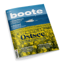 Magazincover Boote, eine weiße Motoryacht auf blauem Meer vor einem Feld aus gelben Blumen, Schlagzeile Revier-Update Ostsee.