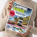 Weibliche Person im beigefarbenen Strickpullover hält eine schräg ausgerichtete, glänzende Zeitschrift aus Papier. Das Cover trägt die Texte „CAMPING & REISE“, „Routen ins Glück – Die schönsten Reisen in Europa“, „Neuheiten 2027“ und „Spezial: 12 Seiten zum CARAVAN SALON“ und zeigt einen Campingbus vor mediterraner Landschaft sowie weitere Reisefotos.