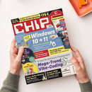 Titelblatt des Technikmagazins „CHIP“ mit rotem Logo oben links, Hauptaufschrift „Windows 10 → 11“ auf blauem Hintergrund, weiteren Textfeldern zu Themen wie „Mega-Trend Vibe-Coding“, „Linux light“, „VPNs im CHIP-Check“ und „Die besten Handys unter 600 Euro“. Im oberen Bereich kleinere Produktabbildungen von Software-Boxen und DVDs, gehalten von zwei Händen vor hellem, neutralem Hintergrund.