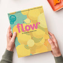 Bunt gestaltetes Magazincover „flow“ mit gelber, türkisfarbener und orangefarbener Kreisgrafik, weiß geschwungenen Linien und kleiner stehender Figur; darunter der Text „Do what you love and start today.“ Oben steht „DAS MAGAZIN FÜR PERSÖNLICHE ENTWICKLUNG, KREATIVITÄT & MEHR RUHE“, links „100. AUSGABE“; zwei Hände halten das Magazin vor weißem Hintergrund.
