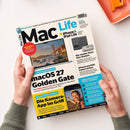 Schräg auf einer weißen Fläche liegt das Magazin „Mac Life“, das von zwei Händen mit grauen Strickärmeln gehalten wird; oben rechts ist teilweise eine orange Schale mit Metallklammer sichtbar. Auf dem Cover stehen „iPhone Ultra: Apples große Pläne für das kommende Spitzenmodell“, „iPhone & iPad Life“, „macOS 27 Golden Gate“, „Nie wieder fiese Abo-Kosten“ und „Die Kamera-App im Griff“.