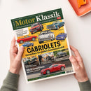 Schräg von oben fotografierte Zeitschrift „Motor Klassik“ mit grün-gelbem Cover, gehalten von zwei Händen einer nicht erkennbaren Person. Sichtbare Texte: „Die faszinierende Welt von Oldtimern und Youngtimern“, „Rekorde und Rabatte“, „CABRIOLETS“, „Genießen Sie jeden Sonnenstrahl!“ sowie „Alfa 8C Competizione“; abgebildet sind mehrere klassische Fahrzeuge in verschiedenen Farben.