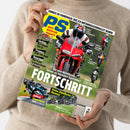 Weibliche Person im beigefarbenen Strickpullover hält ein schräg fotografiertes Magazincover aus Papier. Darauf stehen „PS Sport Motorrad magazin“, „Zon­kos Er-Fahrungen: Wie ich Motorradjournalist wurde“, „Edelbike BOT-Ducati 900 SS“, „Premiere KTM 790 Duke“, „Reportage Flat-Track in Deutschland + Historie“ und „Fünf Sportler“; abgebildet sind mehrere Motorräder und Motorradfahrende.