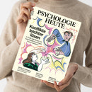 Weibliche Person im beigen Strickpullover hält eine cremefarbene Zeitschrift schräg vor dem Oberkörper. Das Cover trägt den Titel „PSYCHOLOGIE HEUTE“ und die Texte „Konflikte leichter lösen“, „6 Tools, mit denen wir Auseinandersetzungen besser meistern“, „ADHS und Autismus – Ein Leben zwischen zwei Extremen“, „Abnehmen – Verändert es die Liebe?“ sowie „Arbeitsweg – Kreative Lösungen gegen Stress“; farbige Illustrationen zeigen mehrere Personen und Hände.