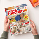 Zeitschrift „selber machen“ mit rotem Titel, Untertitel „Bauen | Gestalten | Renovieren“ und gelbem „DIY Do it yourself“-Logo, von zwei Händen vor weißem Hintergrund gehalten. Das Cover zeigt zwei männliche Personen bei Bauarbeiten sowie Texte wie „Grill mauern“, „Praxistest: Starke Tischfräse für Heimwerker“, „Glatte Wände“, „Neue Bäder“ und „Balkon-Bar“.
