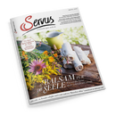 Schräg liegendes Magazin „Servus – einfach gut leben“ mit Blumen und gelbem Becher im Hintergrund sowie drei gerollten weißen Stoffservietten auf einem Holztisch. Titel: „Balsam für die Seele – Wie uns die Natur mehr Lebensfreude schenkt“; weitere Texte: „Paul Pizzera und das Zniachtl“, „Bertl Göttl und die echte Volksmusik“ und „Der beste Kaiserschmarrn der Welt“.