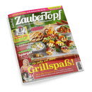 Magazin ZauberTopf Cover: Ein reichhaltiges Grill-Büfett mit Spießen, Salaten und Dips. Eine lächelnde Frau ist im unteren Bereich abgebildet. Hauptschlagzeile: Grillspaß!